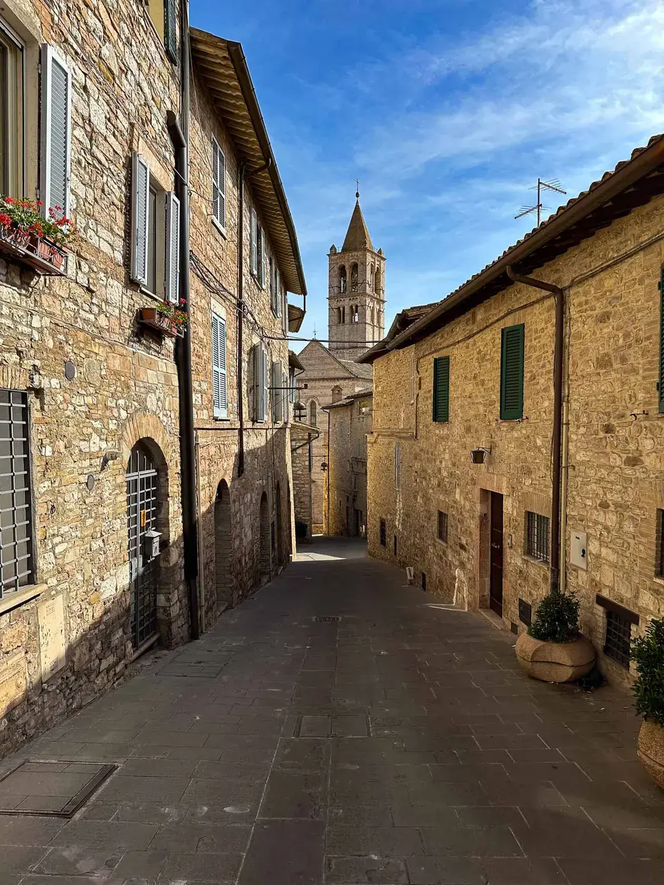 A narrow medieval stone street between old buildings