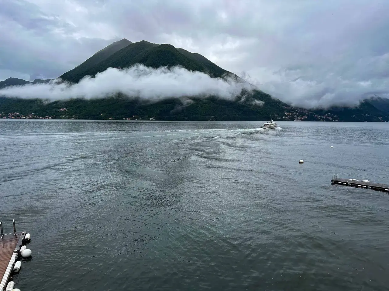 A hazy lake with mountains and a shoreline town