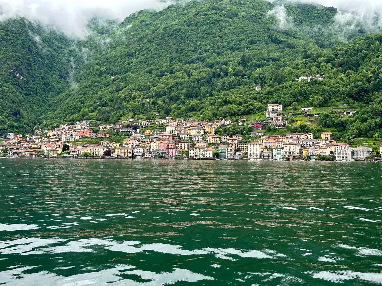 A lakeshore village backed by steep green mountains