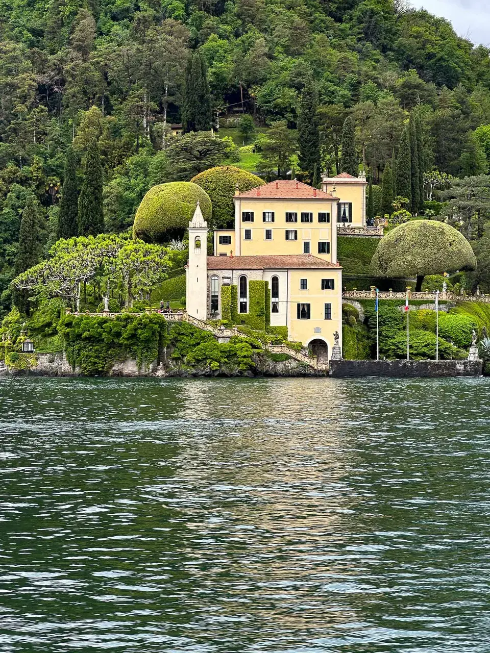 A grand villa with gardens beside the lake