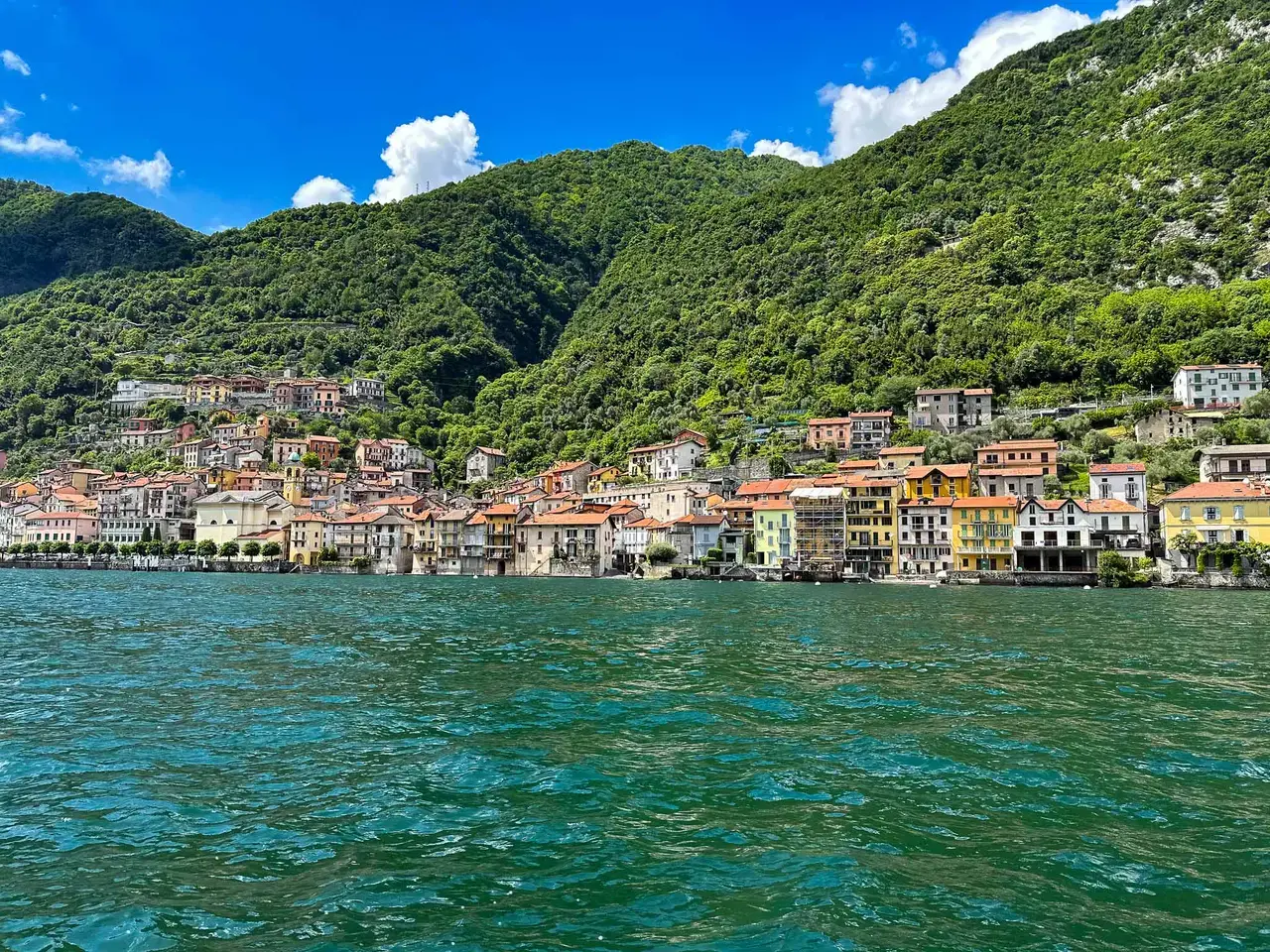 A lake ringed by green mountains, seen from the water