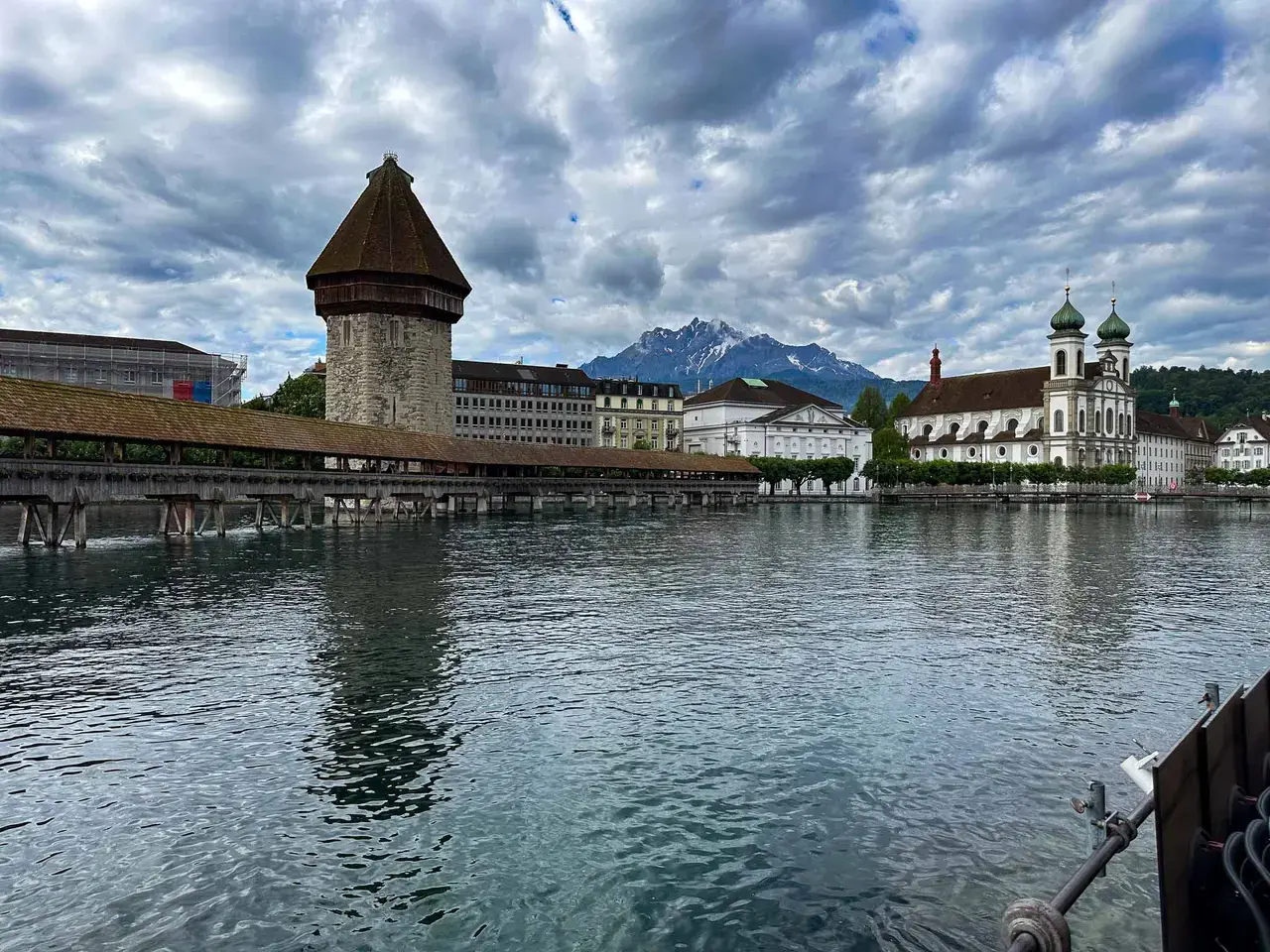 An octagonal stone water tower beside Lake Lucerne