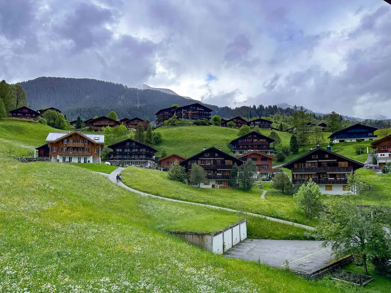 An alpine village in a green valley ringed by mountains