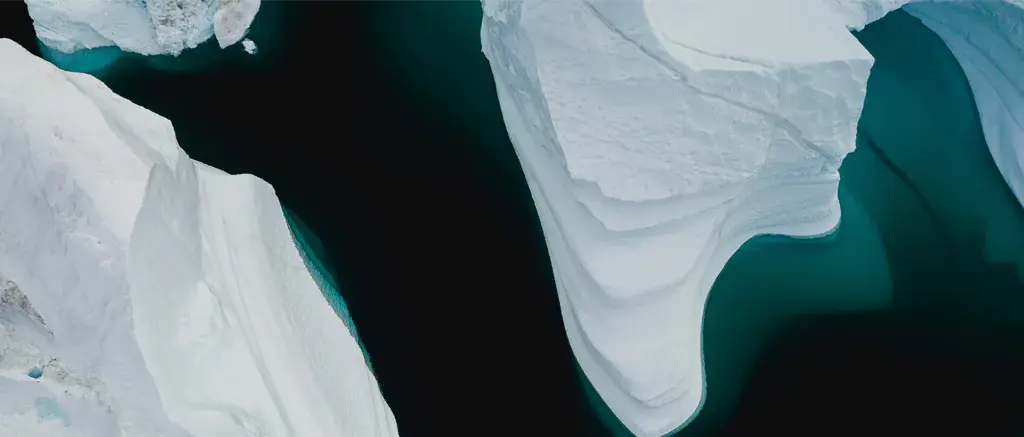 White icebergs in dark blue-green arctic waters